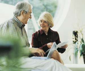 mature couple looking at laptop sitting on a couch